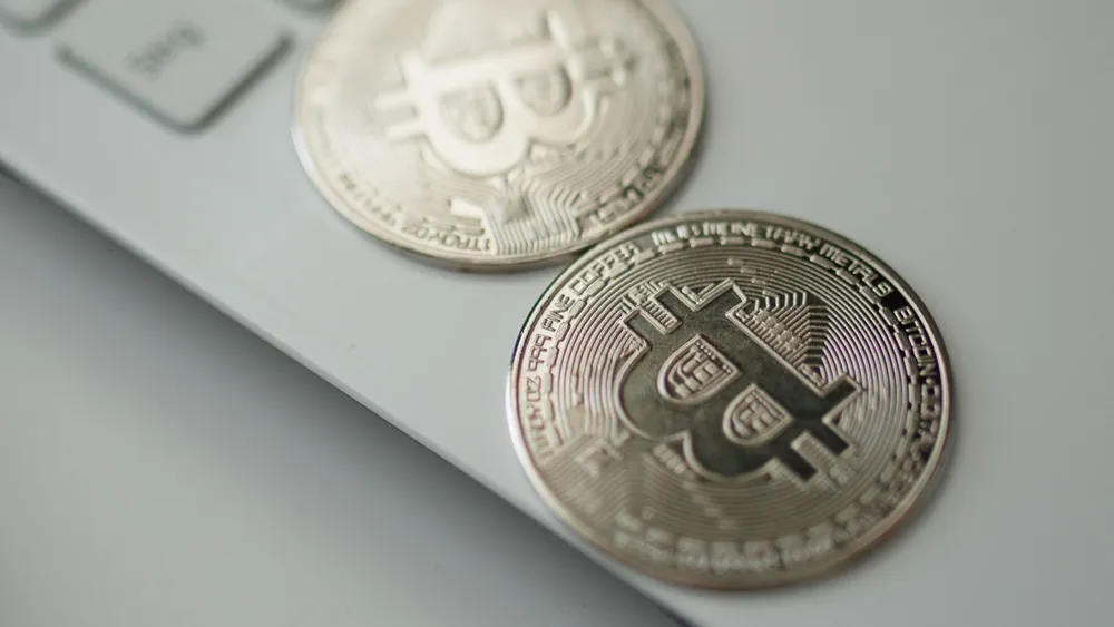 Detail stříbrné mince se symbolem Bitcoinu