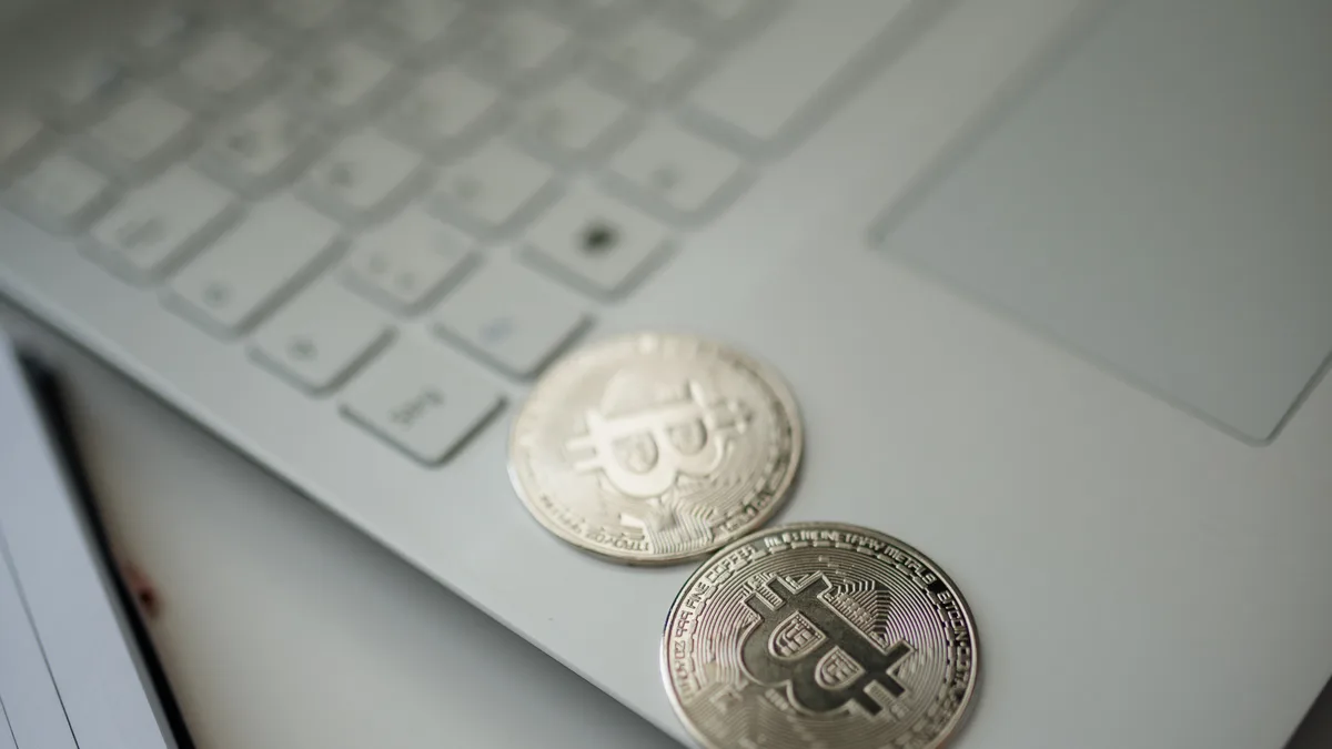 Dvě stříbrné mince s logem Bitcoinu položené na klávesnici notebooku, ilustrace vkladu do krypto casina